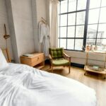 white bed linen near brown wooden chair