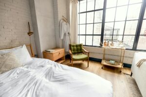 white bed linen near brown wooden chair