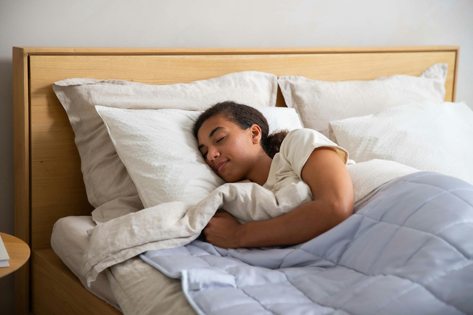 a woman sleeping in a bed with a blanket