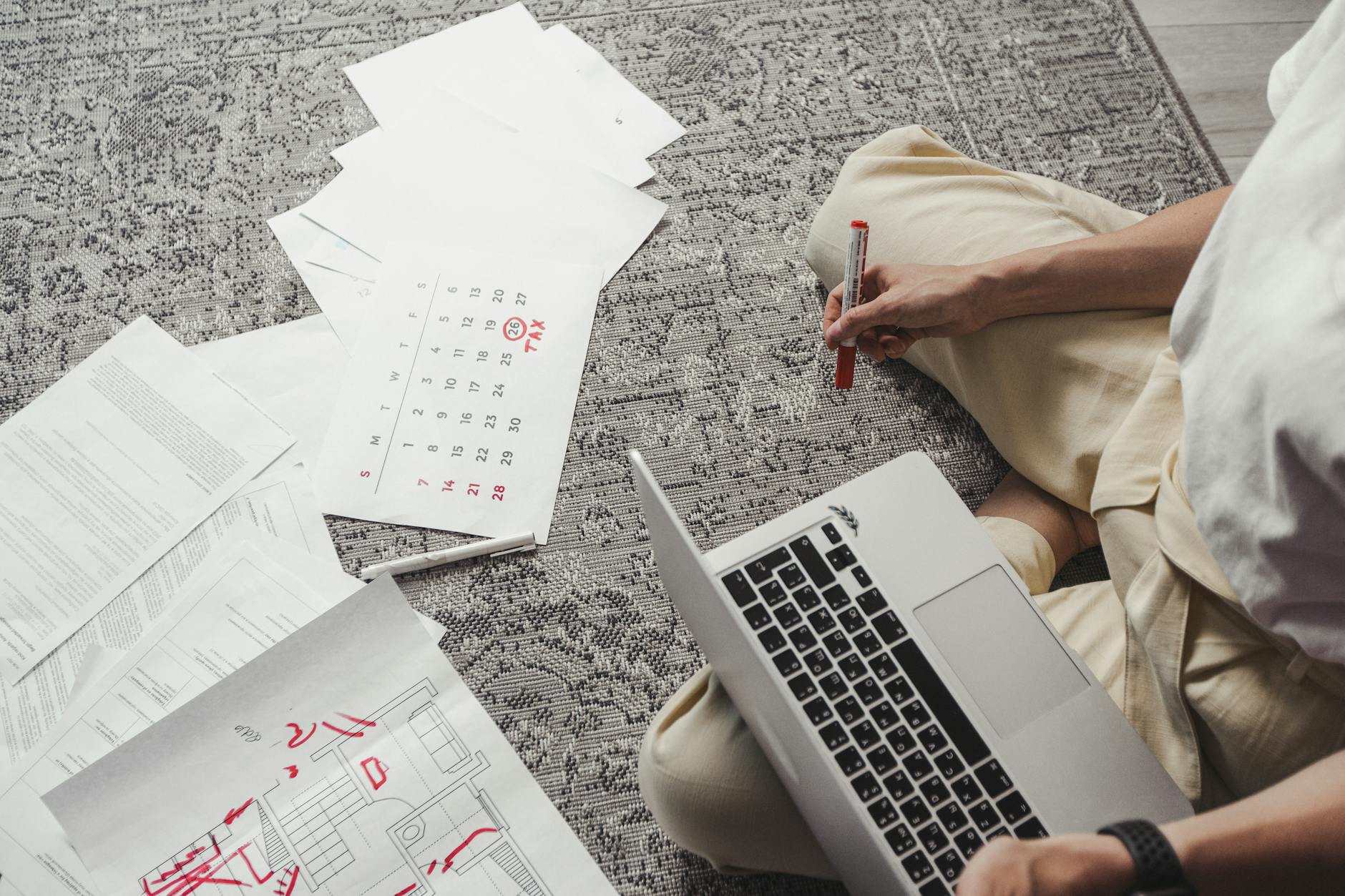 man working on laptop among documents