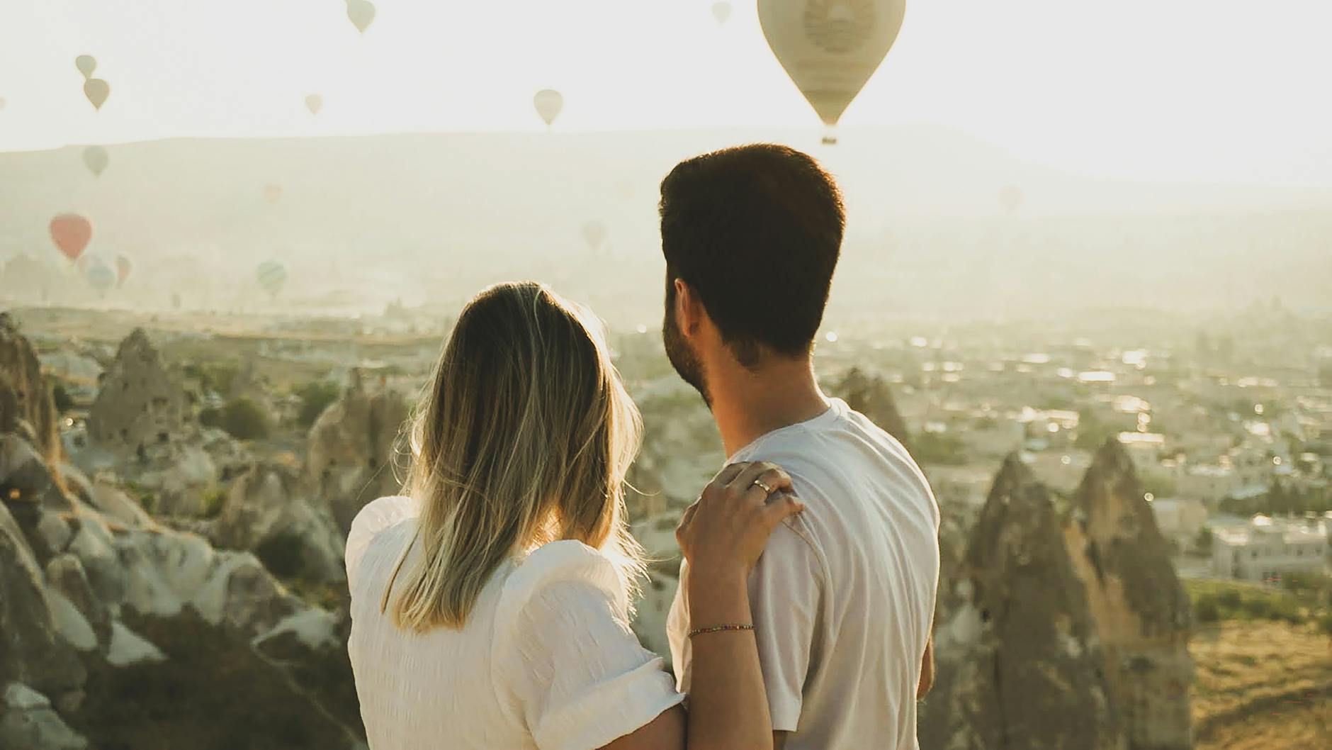 couple watching balloons flying over cappadocia