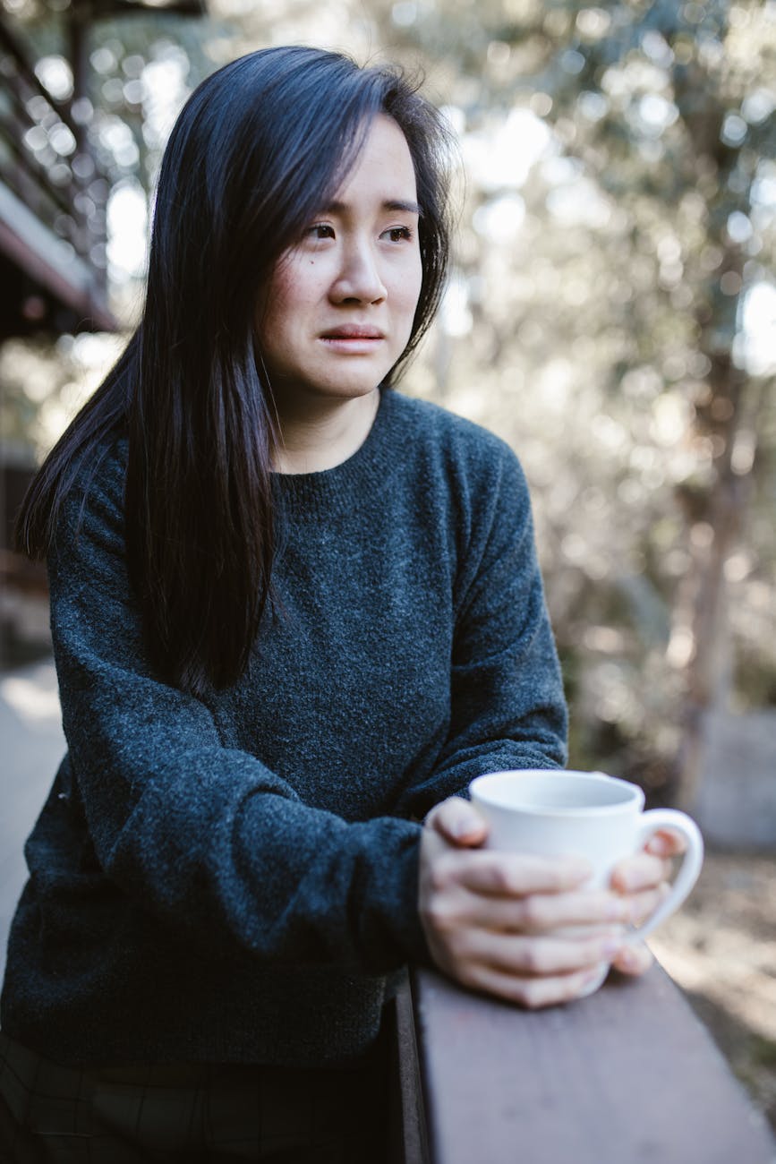 an unhappy woman holding a cup
