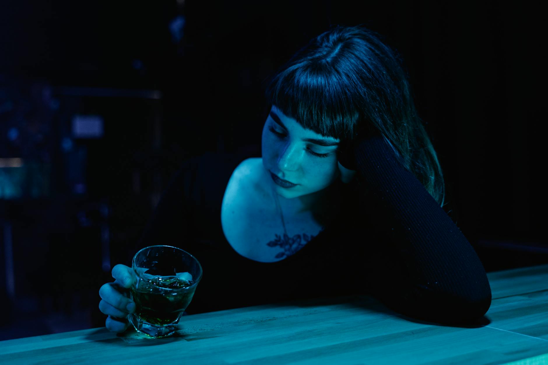 woman holding a drink sitting on the bar
