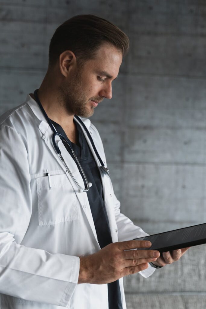 man in white button up shirt holding black tablet computer