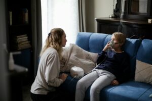 a sick boy in blue long sleeves sitting on the couch